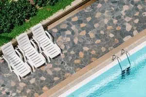 Limpeza e revitalização de pedras ao redor de piscina